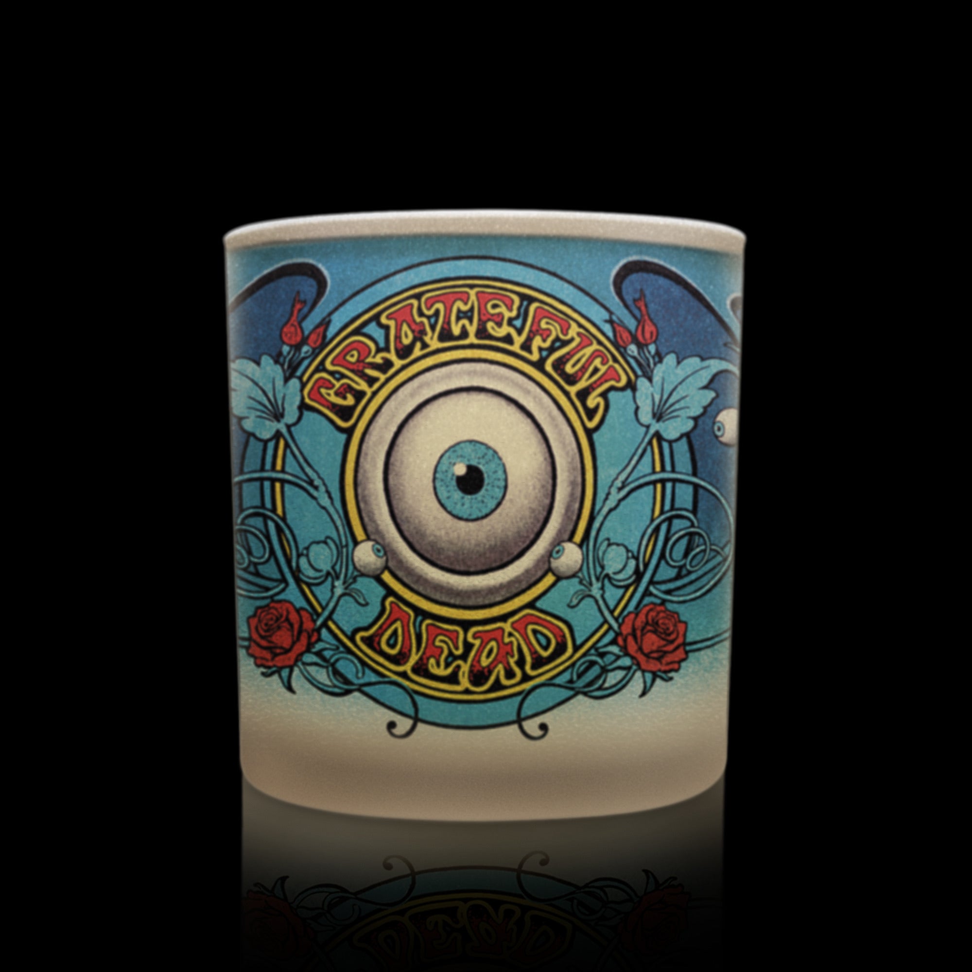 Candle with Grateful Dead eye artwork in blue and red tones